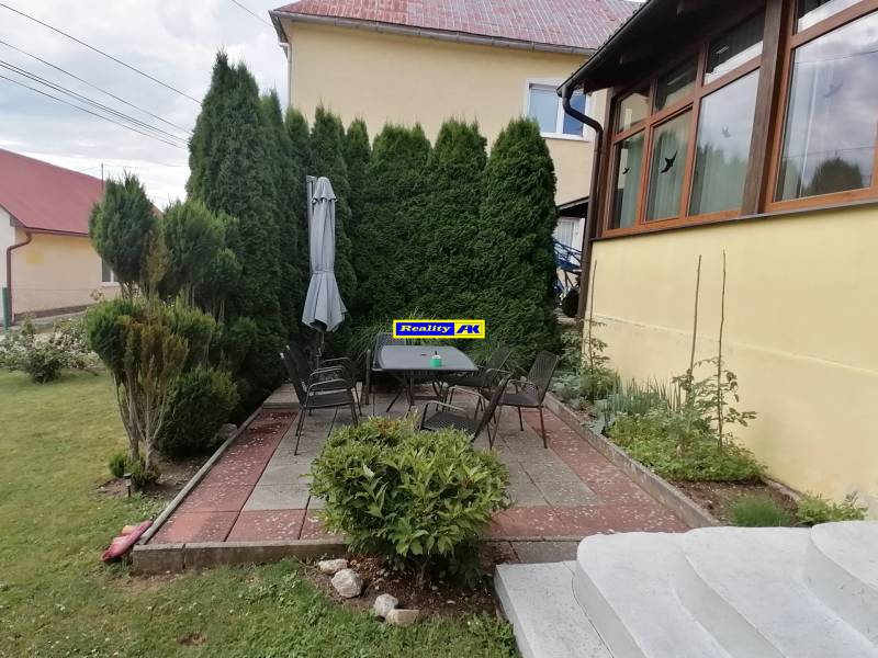 Rodinný dom Mošovce, Turčianske Teplice: terasa so záhradným nábytkom a tujami v záhrade.