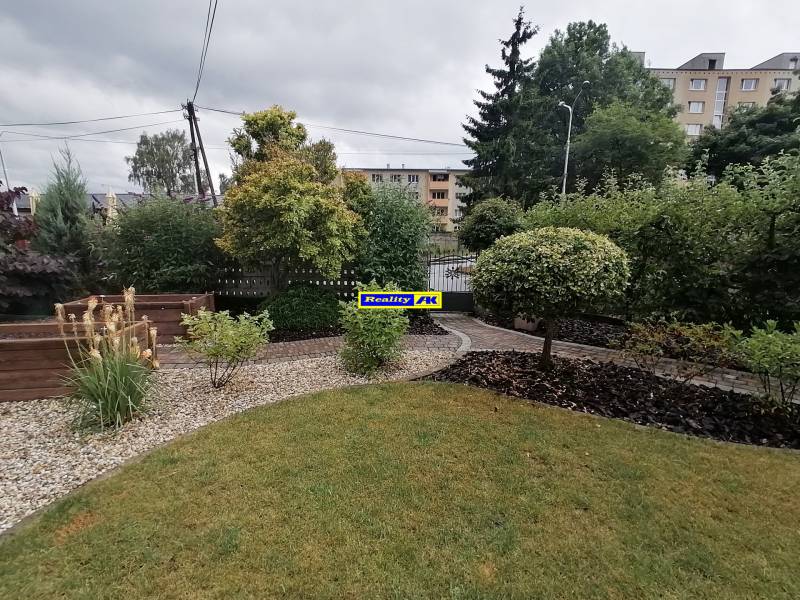 Záhrada pri rodinnom dome na ulici J.Š.Šikuru v Martine s chodníkom a zeleňou.