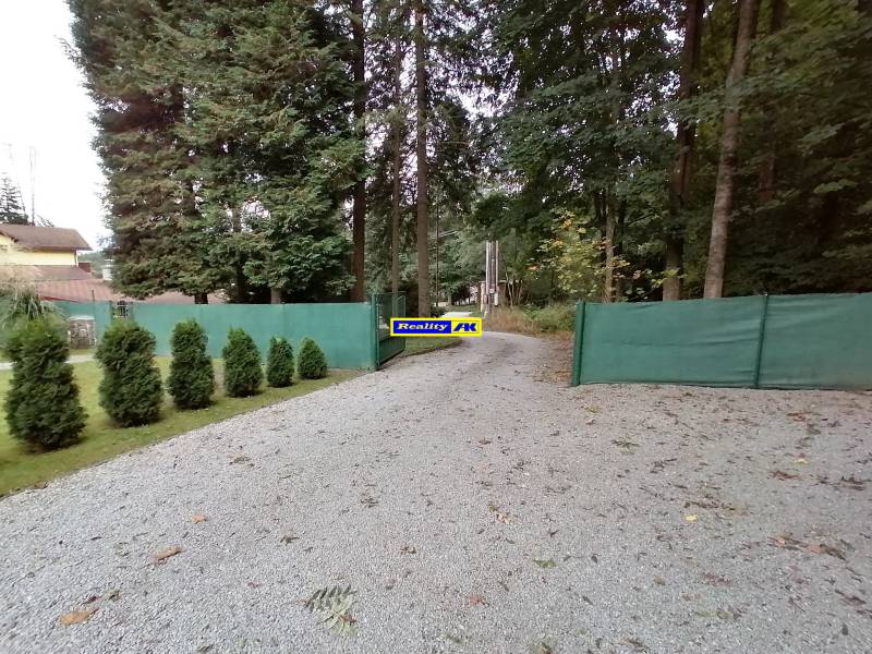 Štrková cesta obklopená stromami a zeleným plotom na Rekreačných pozemkoch v Martine, Hrdinov SNP.