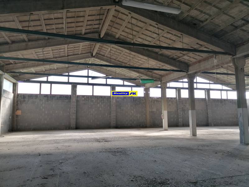 Industriálny priestor s betónovou podlahou a stropom, vhodný pre sklady a haly.