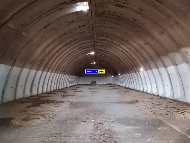 Klenutý sklad s hlinenou podlahou a betónovými stenami, vhodný pre Sklady a haly.