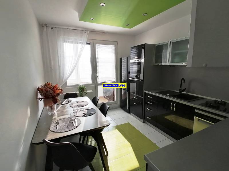 Kuchyňa v 3-izbovom byte s jedálenským stolom a svetlou podlahou.
