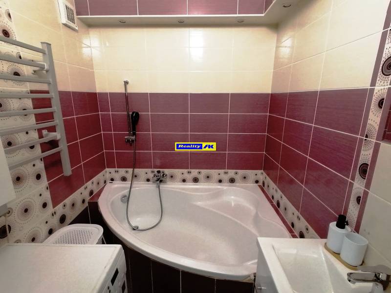 Kúpeľňa v 3-izbovom byte s rohovou vaňou a farebnými obkladmi.