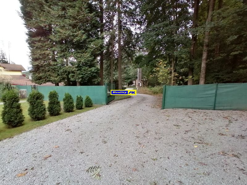 Štrková cesta obklopená stromami a zeleným plotom na Rekreačných pozemkoch v Martine, Hrdinov SNP.