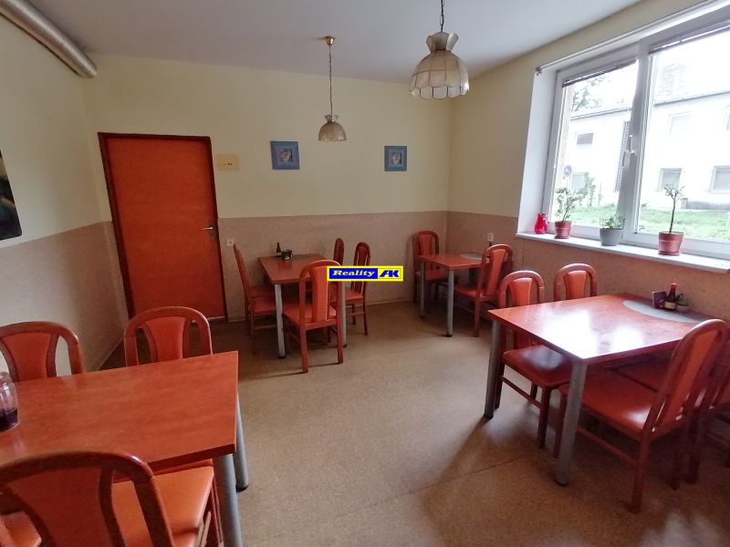 Jasné gastro priestory s nábytkom z dreveného dekoru a veľkým oknom.