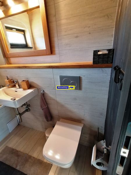 Kúpeľňa vo vile s podlahou s dreveným dekorom a moderným vybavením.