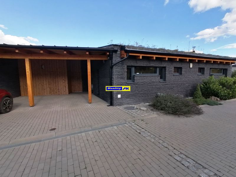 Vila na ulici Bobrovník v Liptovskom Mikuláši s kamennými stenami, dreveným prístreškom a zeleňou.